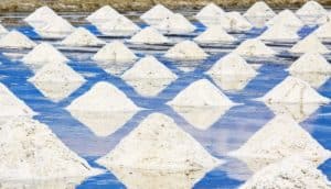 piles of salt in blue water