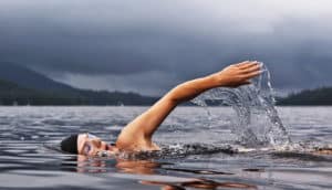 woman swims in gloomy lake