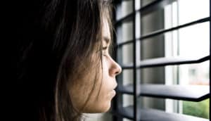 young woman looking through window