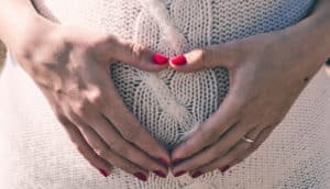 heart hands on woman's stomach