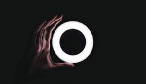 hand holds O on black