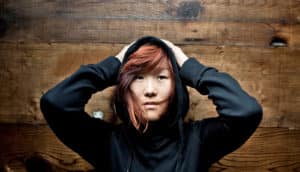 woman in hoodie puts hands on head