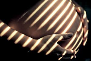 pregnant woman with light on stomach