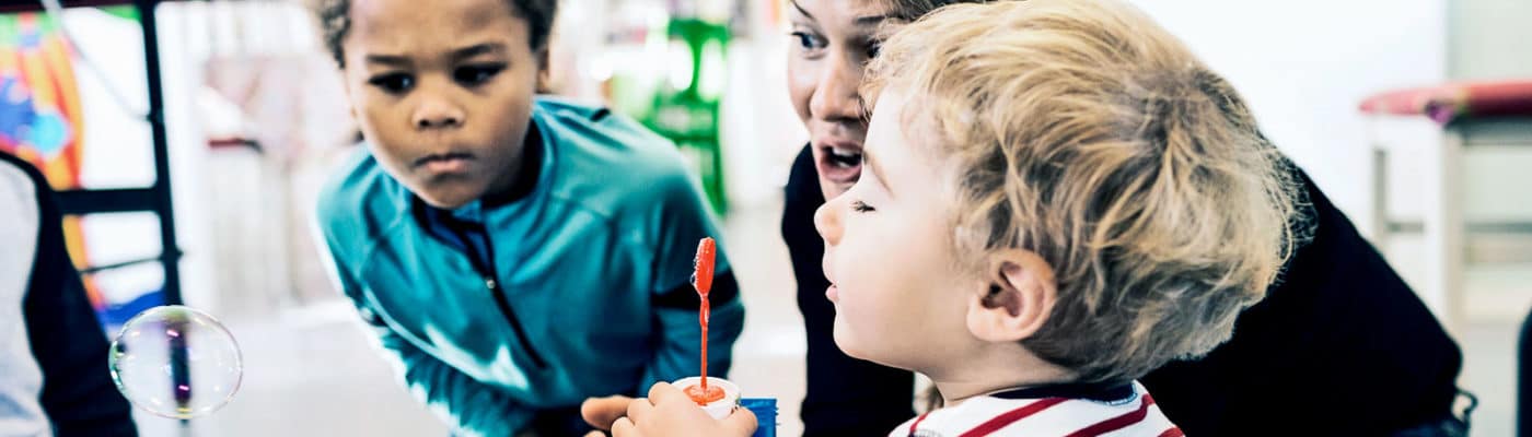 teacher and kids looking at bubble