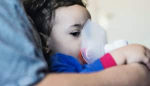 little girl using inhaler (asthma concept)