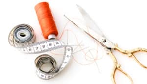 orange thread, measuring tape, gold scissors
