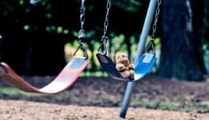 teddy bear on swing alone (child neglect concept)