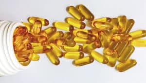 golden vitamin capsules spill from bottle
