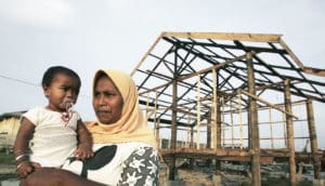 woman and baby in front of Banda Aceh reconstruction