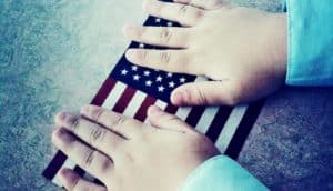 child's hands on the flag of the United States