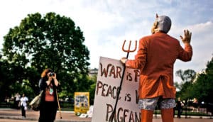 a protestor dressed as the devil (politics + apocalyptic language concept)