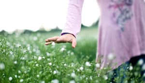 girl's hand touching flowers