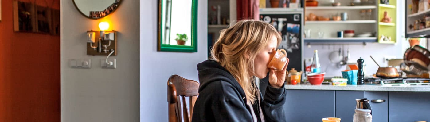icelander in kitchen drinking from mug