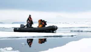 people in kodiak boat in svalbard, arctic