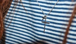 cross necklace on striped shirt