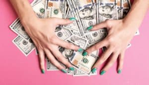 hands with green nails gather $100 bills