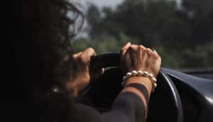 woman's hands on steering wheel