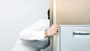 woman leans to open fridge