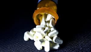 spilling oxycodone pills (opioid addiction gene variant concept)