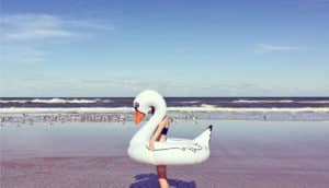 person in swan float at ocean (sunscreen and shinorine concept)