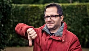 man in red parka gives thumbs down