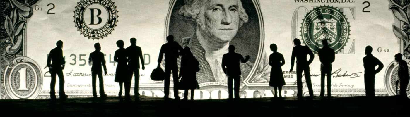 miniature silhouettes in front of dollar
