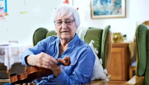 woman tuning violin (dementia concept)