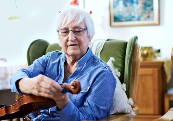 woman tuning violin (dementia concept)