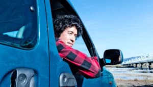 man looking out car window (chronic angina + optimism concept)