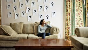 woman on couch with question marks on wall
