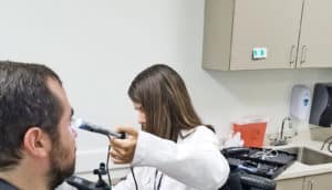 doctor checking eye (doctors with disabilities concept)