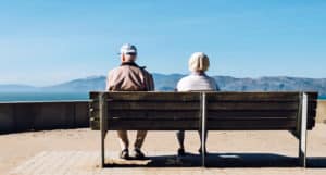elderly couple on bench facing away - dementia concept