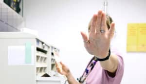 nurse holds up hand to say "stop"