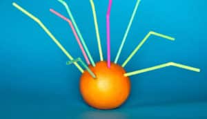 straws stuck in an orange