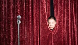 man behind curtain on stage