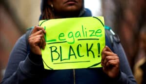 protestor outside Philly Starbucks with "Legalize Black!" sign. Starbucks anti-bias training