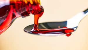 red cough medicine pouring into spoon