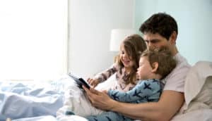 dad with two toddlers in bed - apps for preschoolers