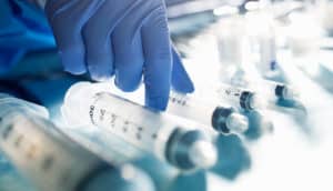 gloved hand with syringes - bladder cancer