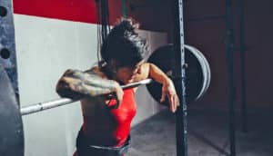 woman makes face while lifting weights - lactate