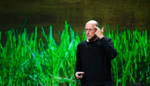 Michael Pollan on stage, pointing at head