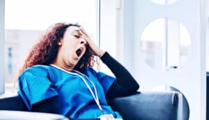 nurse yawning at work (sleep concept)