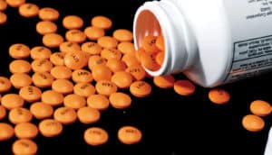 orange aspirin on black (blood pressure drugs)
