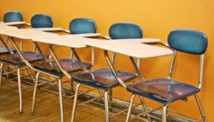 blue school desks against orange wall