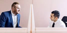 two coworkers in pink cubicles (cooperation concept)