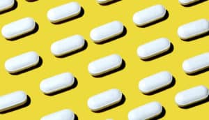 white pills on yellow (antipsychotics concept)