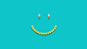 pills in shape of smiley face (side effects concept)