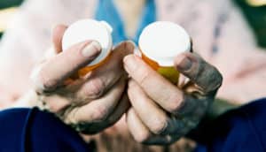 senior holding pill bottles (benzodiazepines concept)