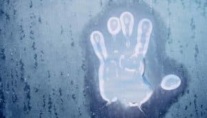 icy handprint on window