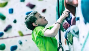 kid on rock climbing wall (weight loss concept)